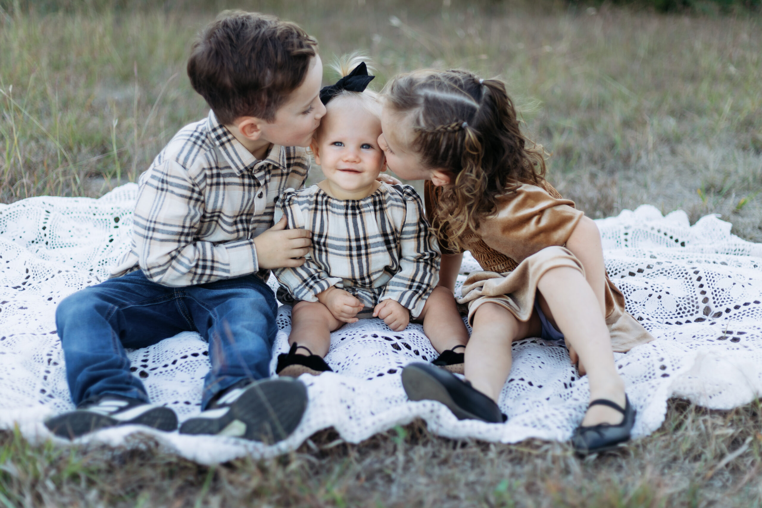 Kids kissing their baby sibling